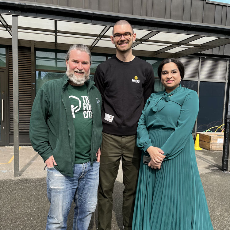 Three people standing in front of a building